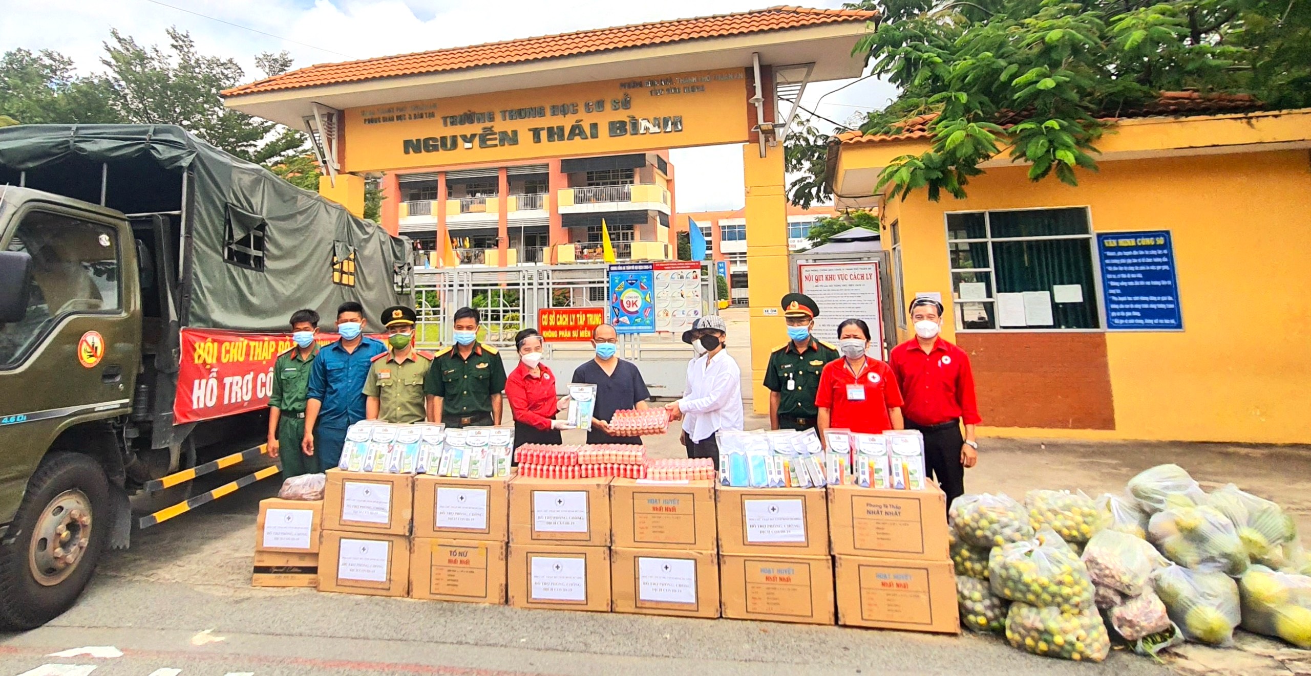 Bà Nguyễn Thị Lệ Trinh, Chủ tịch Hội CTĐ tỉnh Bình Dương (thứ 5, trái sang) và ông Tống Xuân Giang, Phó Chủ tịch Hội CTĐ tỉnh Bình Dương (bìa phải) trao quà của Bình Phước cho khu cách ly tại Trường THCS Nguyễn Thái Bình