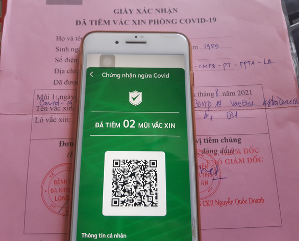 Người đi đường tại Long An có thể mở ứng dụng trên điện thoại hoặc giấy tiêm chủng kèm giấy tờ tùy thân để chứng nhận đủ điều kiện 