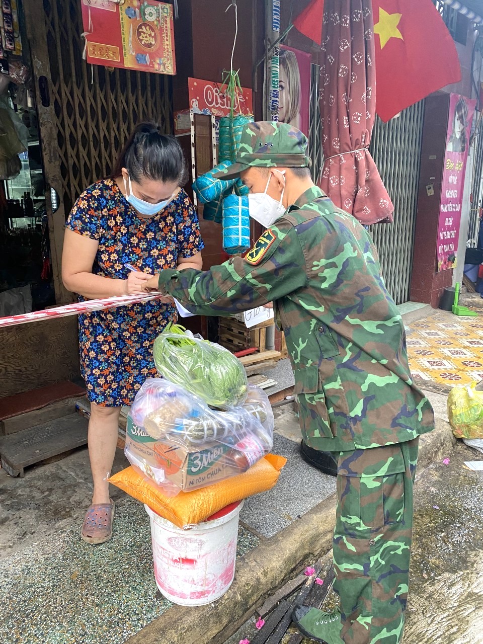 Một chiến sĩ trẻ đang gửi tặng túi an sinh từ Bình Phước cho một hộ gia đình tại Quận Bình Thạnh (TP Hồ Chí Minh)