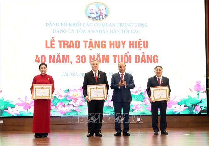 Chủ tịch nước Nguyễn Xuân Phúc trao Huy hiệu 40 năm, 30 năm tuổi Đảng cho các đại biểu. Ảnh: Phạm Kiên/TTXVN