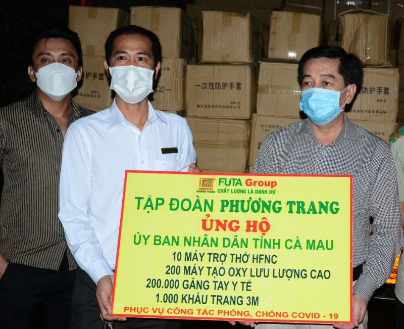Phó Giám đốc công ty cổ phần xe khách Phương Trang chi nhánh Nguyễn Thanh Liêm (giữa) trao bảng tượng trưng ủng hộ máy móc, thiết bị y tế cho tỉnh Cà Mau