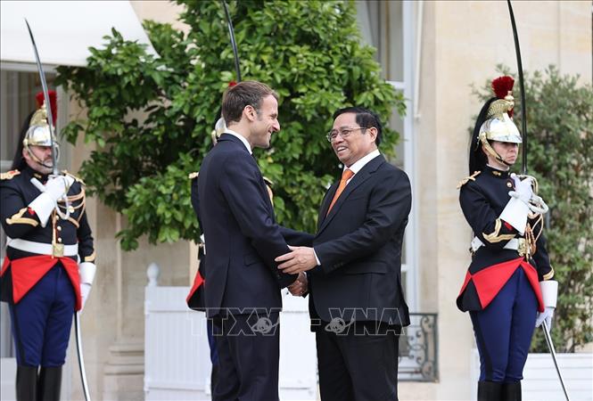 Tổng thống Cộng hòa Pháp Emmanuel Macron đón Thủ tướng Chính phủ Phạm Minh Chính. Ảnh: Dương Giang/TTXVN