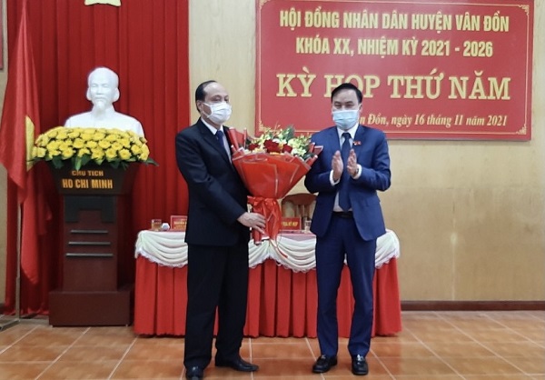 Ông Trương Mạnh Hùng, Bí thư Huyện ủy Vân Đồn tặng hoa chúc mừng ông Vũ Đức Hưởng, tân Chủ tịch UBND huyện Vân Đồn