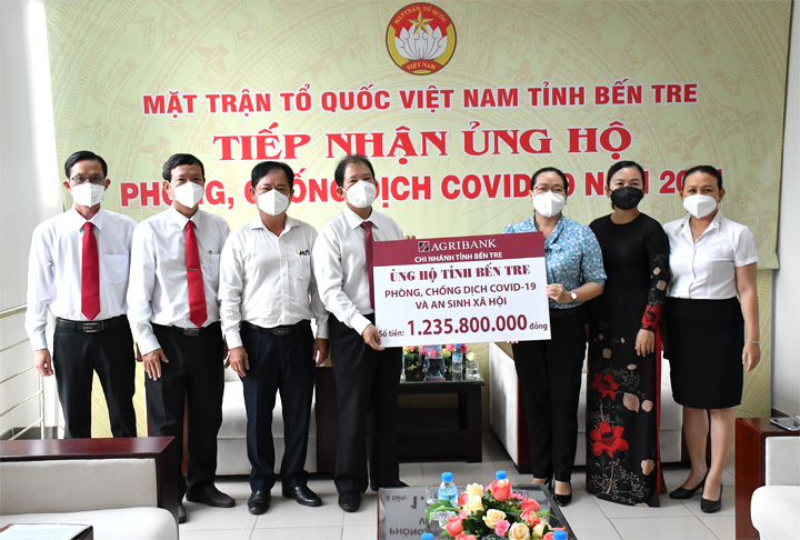 Ông Vũ Hồng Dụ, Giám đốc Ngân hàng Agribank – Chi nhánh Bến Tre trao biển tượng trưng số tiền ủng hộ cho Bí thư Đảng, đoàn Nguyễn Thị Hồng Nhung