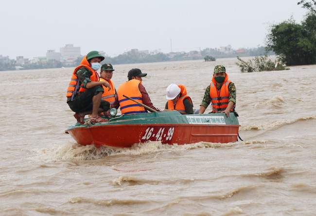 Lực lượng cứu hộ tỉnh Phú Yên dùng xuồng đưa người dân ra khỏi khu vực ngập lụt (Ảnh: TTXVN)
