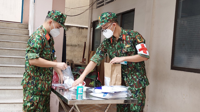 Bác sĩ quân y của trạm y tế lưu động thuộc phường 9, quận Phú Nhuận, Thành phố Hồ Chí Minh đang chuẩn bị đến nhà thăm khám cho F0 (Nguồn ảnh NLĐ)
