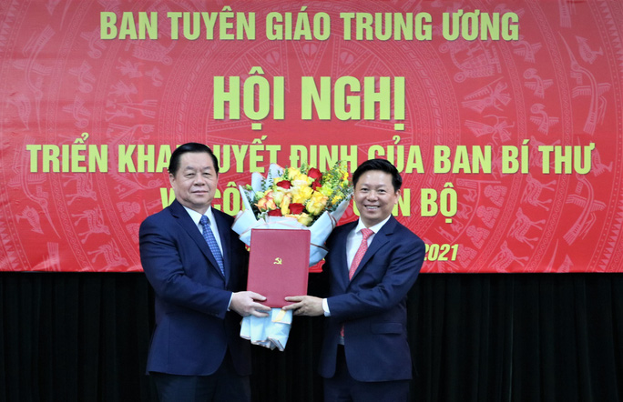Bí thư Trung ương Đảng, Trưởng Ban Tuyên giáo Trung ương Nguyễn Trọng Nghĩa trao quyết định, tặng hoa chúc mừng ông Trần Thanh Lâm (bên phải) - Ảnh: Tuyên giáo