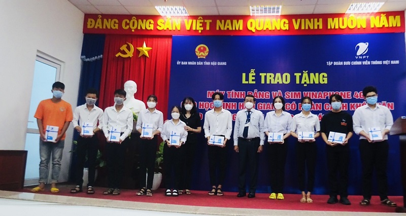 Bà Hồ Thu Ánh, Phó Chủ tịch UBND tỉnh và Trưởng đại diện Tập đoàn VNPT tại Hậu Giang trao tặng máy tính bảng cho các em học sinh