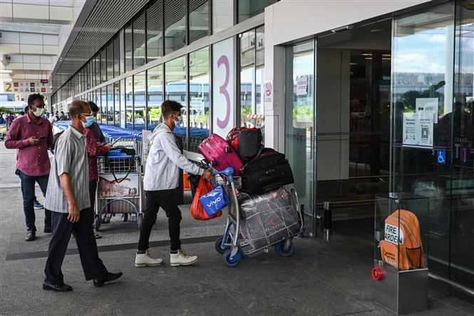 Hành khách đeo khẩu trang phòng dịch COVID-19 tại sân bay quốc tế Changi, Singapore. Ảnh: AFP/ TTXVN