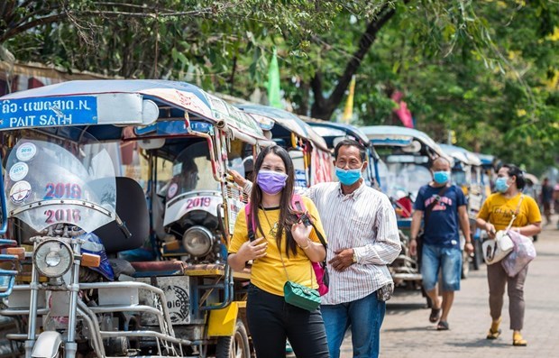 Người dân Lào đeo khẩu trang phòng dịch COVID-19. Ảnh: TTXVN/THX