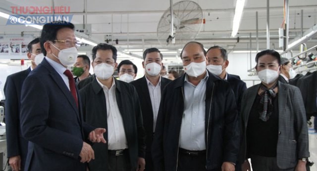 Chủ tịch nước Nguyễn Xuân Phúc (thứ hai, phải sang), Bí thư Thành ủy Nguyễn Văn Quảng (thứ hai, trái sang) cùng lãnh đạo thành phố thăm phân xưởng sản xuất của Công ty CP Dệt may 29-3