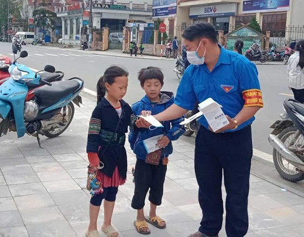 Thào A Dê tuyên truyền phòng chống dịch Covid-19 và phát khẩu trang cho người dân, trẻ em tại địa phương