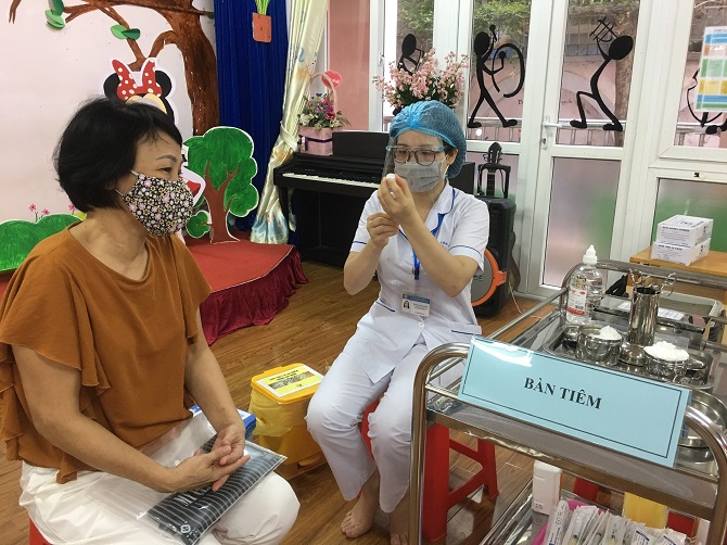 Cán bộ y tế tiêm vắc xin phòng Covid-19 cho người dân trên địa bàn thành phố Hà Nội