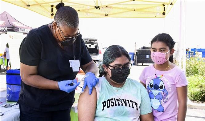 Nhân viên y tế tiêm vaccine ngừa Covid-19 cho trẻ em tại Los Angeles, California, Mỹ (Ảnh: AFP/TTXVN)