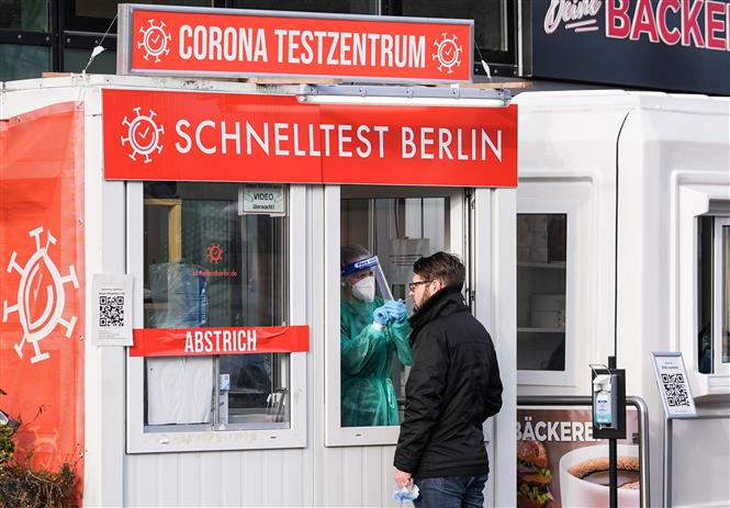 Nhân viên y tế lấy mẫu xét nghiệm Covid-19 cho người dân tại Berlin, Đức, ngày 19/1/2022 (Ảnh: THX/TTXVN)