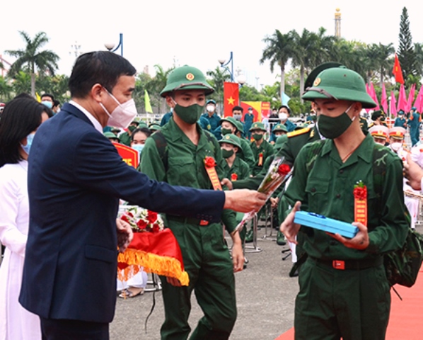 Chủ tịch UBND TP. Đà Nẵng Lê Trung Chinh (trái) tặng hoa và động viên các tân binh lên đường làm nhiệm vụ
