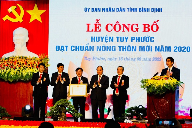 Chủ tịch nước Nguyễn Xuân Phúc (thứ 4 từ trái qua) trao quyết định công nhận huyện Tuy Phước đạt chuẩn nông thôn mới năm 2020 cho lãnh đạo huyện Tuy Phước.