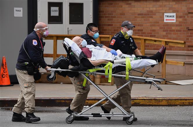 Nhân viên y tế chuyển bệnh nhân Covid-19 vào bệnh viện ở New York, Mỹ (Ảnh: AFP/TTXVN)