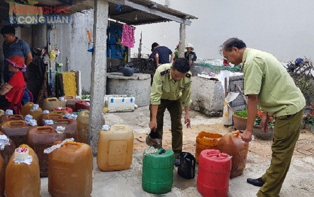 Lực lượng Đội QLTT số 3 đang kiểm tra các can chứa chất lỏng nghi dầu DO.