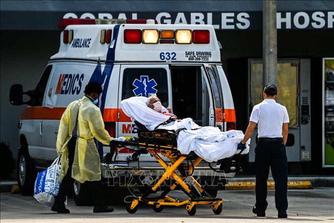 Nhân viên y tế chuyển bệnh nhân Covid-19 tới bệnh viện ở Coral Gables, gần Miami, Mỹ (Ảnh: AFP/TTXVN)