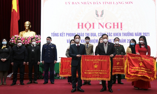 Chủ tịch UBND tỉnh Lạng Sơn Hồ Tiến Thiệu (bìa phải) tặng cờ thi đua tới lãnh đạo huyện Cao Lộc - đơn vị dẫn đầu phong trào thi đua yêu nước năm 2021