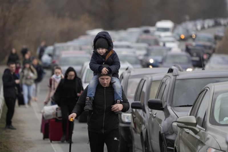 Người tị nạn Ukraine đi bộ dọc theo dòng phương tiện xếp hàng chờ qua cửa khẩu Mayaky-Udobne tại biên giới Ukraine - Moldova. Ảnh Reuter