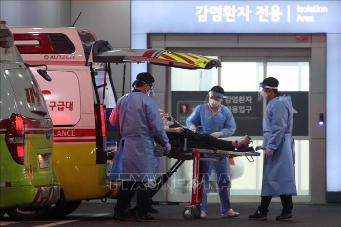 Nhân viên y tế chuyển bệnh nhân Covid-19 tới bệnh viện tại Seoul, Hàn Quốc, ngày 22/03/2022 (Ảnh: THX/TTXVN)