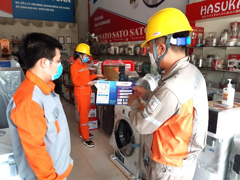 Nhân viên Điện lực Quang Bình phổ biến, tuyên truyền đến các khách hàng có sản lượng điện tiêu thụ cao, cam kết cắt giảm phụ tải trong mùa nắng nóng, sử dụng điện tiết kiệm, an toàn để chia sẻ khó khăn với ngành điện