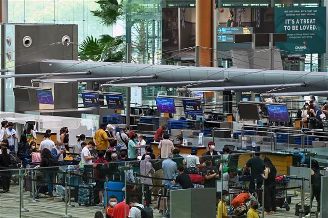 Hành khách làm thủ tục tại sân bay quốc tế Changi, Singapore, ngày 01/04/2022 (Ảnh: AFP/TTXVN)