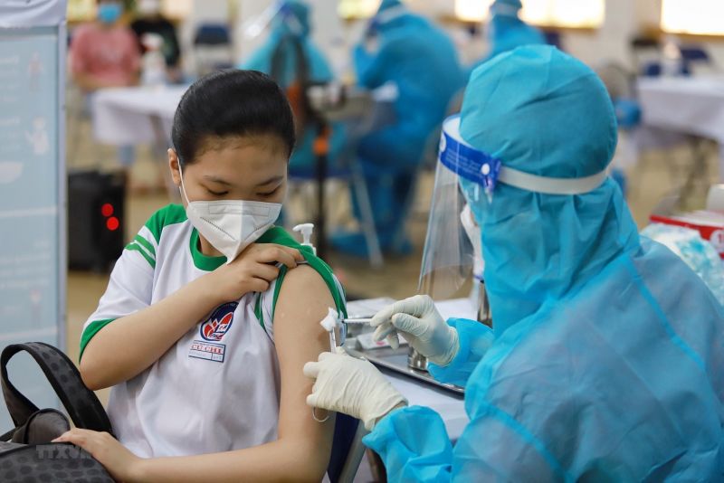 Nhân viên y tế tiêm vaccine cho học sinh
