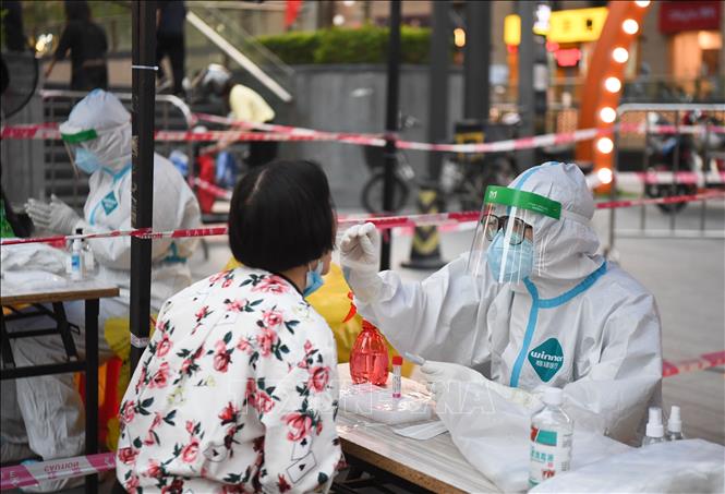 Nhân viên y tế lấy mẫu xét nghiệm Covid-19 cho người dân tại Quảng Châu, Trung Quốc, ngày 09/04/2022 (Ảnh: AFP/TTXVN)
