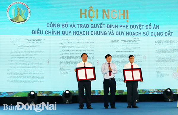 Chủ tịch UBND tỉnh Cao Tiến Dũng (giữa) trao quyết định phê duyệt đồ án diều chỉnh TP. Long Khánh cho lãnh đạo UBND TP. Long Khánh