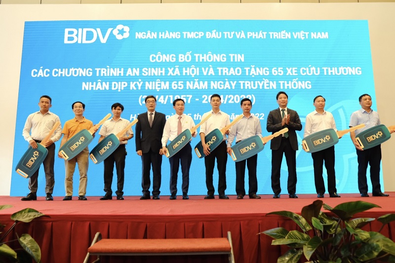Ủy viên HĐQT BIDV Yoo Je Bong và Phó Tổng Giám đốc Trần Phương trao biểu trưng xe cứu thương cho đại diện các địa phương