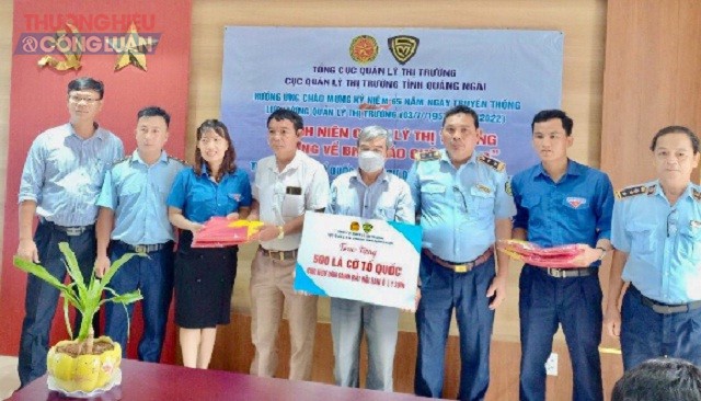 Đại diện lãnh đạo Cục QLTT tỉnh Quảng Ngãi và UBND huyện đảo Lý Sơn trao tặng 500 lá cờ Tổ quốc cho đại diện Nghiệp đoàn nghề cá An Vĩnh và An Hải.