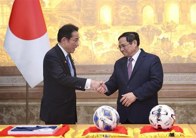 Thủ tướng Phạm Minh Chính và Thủ tướng Nhật Bản Kishida Fumio với tặng phẩm là 02 quả bóng có chữ ký của đội tuyển bóng đá 02 nước