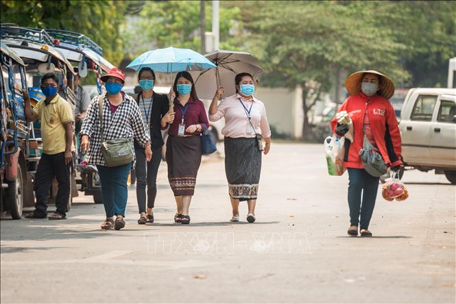 Người dân đeo khẩu trang phòng lây nhiễm Covid-19 tại Viêng chăn, Lào, ngày 23/03/2020 (Ảnh: THX/TTXVN)