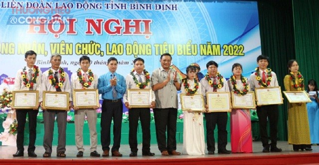 Ồng Lê Kim Toàn (thứ 6 từ phải qua) và ông Nguyễn Mạnh Hùng (thứ 4 từ trái qua) trao Bằng khen và tặng hoa cho các CN-VC-LĐ tiêu biểu.