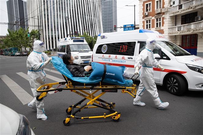 Nhân viên y tế chuyển bệnh nhân nhiễm Covid-19 tới bệnh viện ở Thượng Hải, Trung Quốc, ngày 09/05/2022 (Ảnh: THX/TTXVN)