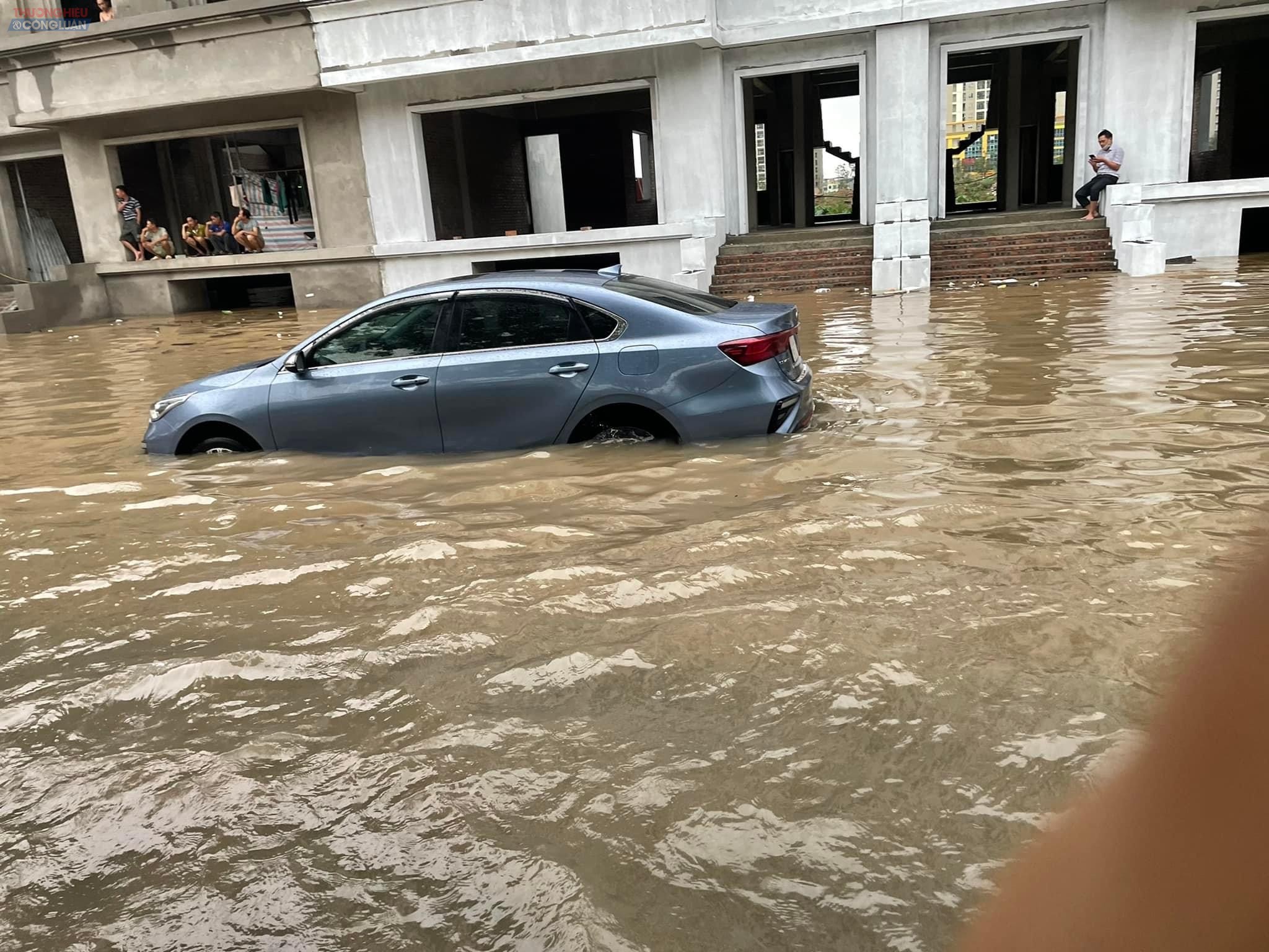 Một chiếc ô tô bị đi i trong làn đường gom khu liền kề KĐT hai bên đường Lê Trọng Tấn bị ngập tới hông xe.