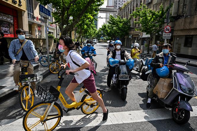 Người dân di chuyển trên một đường phố ở Thượng Hải, ngày 25/05/2022 (Ảnh: AFP/TTXVN)