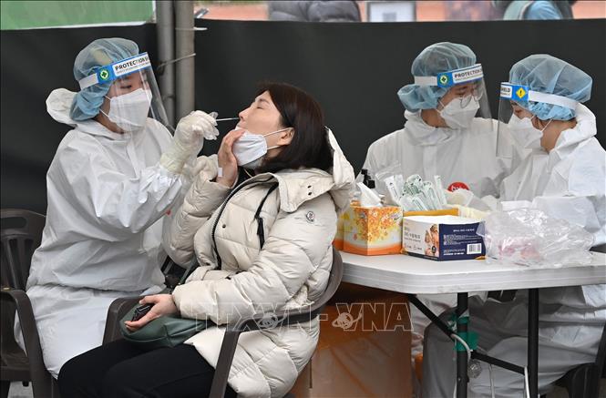 Nhân viên y tế lấy mẫu xét nghiệm Covid-19 cho người dân tại Seoul, Hàn Quốc (Ảnh: AFP/TTXVN)