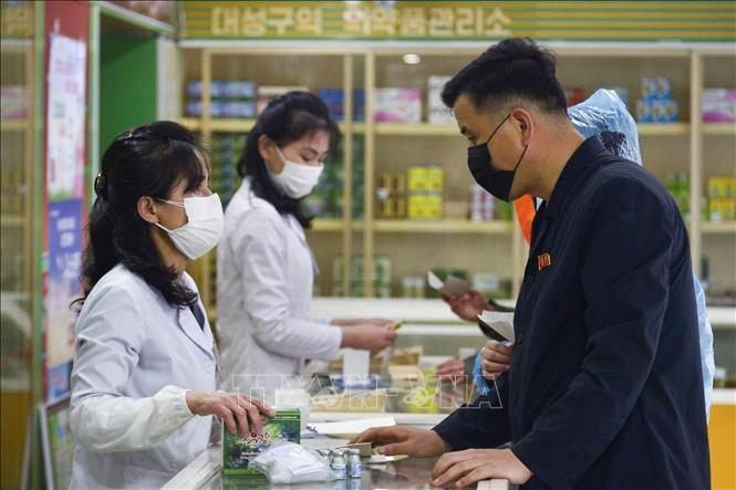 Người dân đeo khẩu trang phòng dịch Covid-19 tại hiệu thuốc ở Bình Nhưỡng, Triều Tiên (Ảnh: Kyodo/TTXVN)