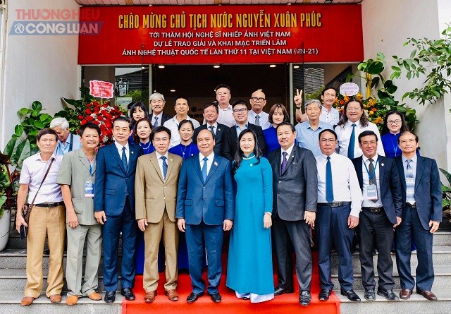 Chủ tịch nước Nguyễn Xu&acirc;n Ph&uacute;c (h&agrave;ng đầu, thứ 5 từ tr&aacute;i qua) chụp cảnh lưu niệm với c&aacute;c đại biểu dự khai mạc triển l&atilde;m Ảnh nghệ thuật Quốc tế lần thứ 11.