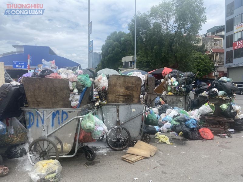 Nhiều xe rác để ngay dưới lòng đường Trần Vỹ, ngổn ngang rác thải gây khó khăn cho người đi đường và gây ô nhiễm môi trường.