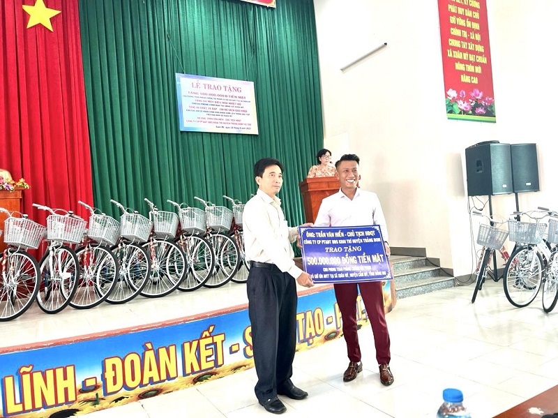 Ông Trần Văn Hiển - Chủ tịch HĐQT Công ty bất động sản Khai Trí (bên phải) trao quà cho đại diện Ban chỉ đạo phong trào
