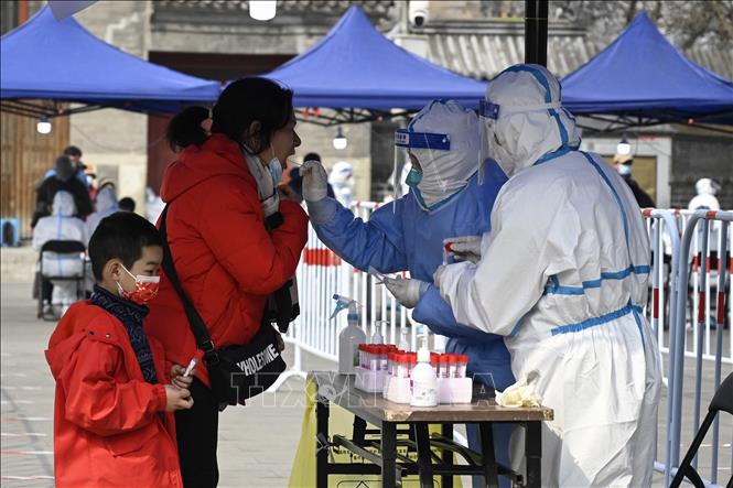 Nhân viên y tế lấy mẫu xét nghiệm Covid-19 cho người dân tại Bắc Kinh, Trung Quốc ngày 23/03/2022 (Ảnh: AFP/TTXVN)