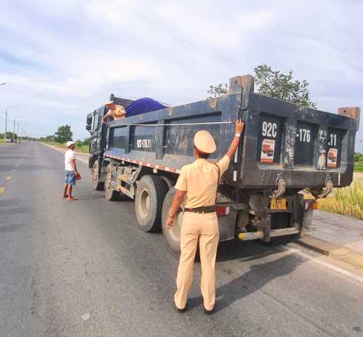 Lực lượng CSGT Thị Xã Điện Bàn, tỉnh Quảng Nam, đang làm nhiệm vụ đo đạc, kiểm tra đối với các xe vận tải đã cắt bỏ, tháo dỡ thùng xe trên tuyến DT 609
