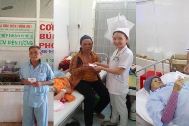 Các nhân viên y tế đang cung cấp phiếu ăn cho bệnh nhân nghèo tại giường bệnh.