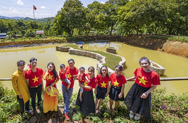 Nhiều gia đình cùng nhau mặc áo cờ đỏ sao vàng đến checkin cùng với bản đồ Việt Nam được xây từ 350.000 viên đá cuội để giáo dục các con lòng yêu nước.