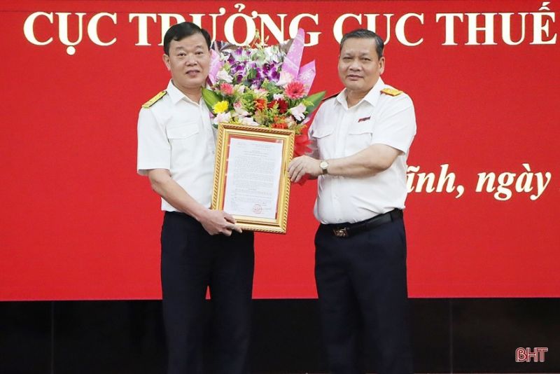 Phó Tổng cục trưởng Tổng cục Thuế Phi Vân Tuấn trao quyết định và tặng hoa chúc mừng ông Trương Quang Long giữ chức Cục trưởng Cục Thuế tỉnh Hà Tĩnh. Ảnh: Phan Trâm
